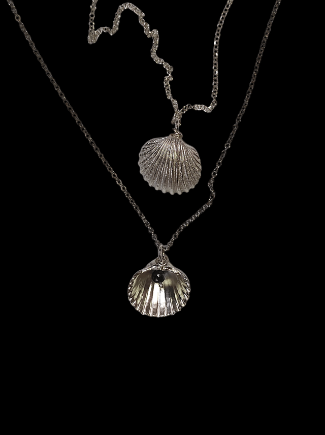 צדף מכסף עם טיפה שחורה של אבן חן. תכשיט דו צדדי .